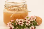 La miel de manuka podría ser un remedio natural para combatir cáncer de mama Flores de manuka junto a tarro con miel