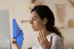 Identifican una variante genética que puede provocar menopausia precoz Una mujer sufiendo sofocos premenopáusicos