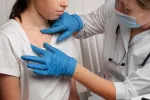 Europa recomienda que la vacuna mpox se pueda administrar a adolescentes Médico revisando la piel de una niña