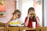 La mitad de las calorías que ingieren los niños procede de ultraprocesados Niños comiendo en un establecimiento de comida rápida