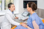 Aumentan la supervivencia en cáncer de mama metastásico con nueva terapia Mujer hablando con su médico sobre la evolución de su cáncer de mama