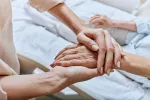 Disponible en España APO-go POD, nuevo fármaco para el párkinson avanzado Enfermera cogiendo las manos de una paciente con parkinson