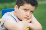 Convierten ácidos grasos dañinos en omega-3 para combatir la obesidad infantil Niño obeso con gesto triste