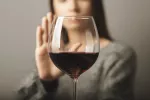 Rechazo los riesgos para la salud de tomar alcohol Mujer rechaza una copa de vino en primer plano