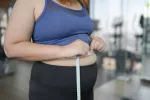 Descubren un nuevo fármaco para perder peso y calorías sin provocar náuseas Mujer obesa midiendo el perímetro de su cintura