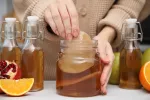 La kombucha mejora síntomas gastrointestinales en personas con sobrepeso Una mujer haciendo kombucha fermentada casera