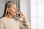 Novedoso espray nasal para tratar el alzhéimer retrasa el deterioro cognitivo Mujer usando un espray nasal
