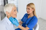 Diagnóstico de cáncer de cabeza y cuello en mujeres Doctora explora cuello de mujer en busca de bultos o tumores