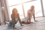 El ejercicio potencia la capacidad de razonar Un hombre y una mujer hacen ejercicio en su casa junto a su perro