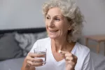 Alertan de los riesgos de un mal uso del paracetamol en mayores de 65 Una mujer mayor sosteniendo una píldora de paracetamol y un vaso de agua