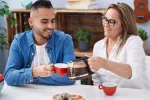 Tomar más de 4 tazas de café al día puede prevenir tumores de cabeza y cuello Una madre madura le sirve café a su joven hijo