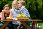 Revelan los factores que influyen en las preferencias de los padres por uno de sus hijos Una niña celosa de su hermano posa junto a este y su madre durante un picnic