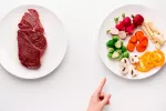 Las alternativas vegetales a la carne ayudan a bajar el colesterol y peso Una mano señalando un plato de verduras en lugar de uno de carne