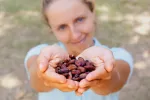 El cacao demuestra ser beneficioso para la memoria y el equilibrio emocional Una mujer mostrando un puñado de granos de cacao en sus manos