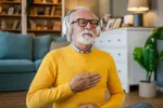 Meditar ayuda a mejorar la memoria y la regulación de emociones Hombre mayor con cascos practica la meditación guiada
