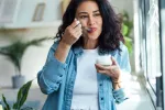 Asocian incluir yogur en la dieta con menor riesgo de cáncer colorrectal Mujer joven disfruta comiendo un yogur en su casa