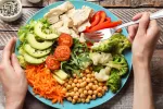 Revelan qué tipo de dieta ayuda a reducir los síntomas de la psoriasis Persona se dispone a comer un plato con verdura, legumbres y carne blanca
