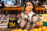 Comer una naranja cada día ayuda a prevenir la depresión Una mujer huele una naranja en un puesto de frutas del mercado