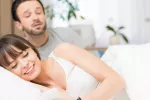 Encuesta sobre relaciones de pareja y sexuales y percepción de la infidelidad en España Hombre mira por encima del hombro de su mujer que está chateando en la cama