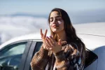 Protector solar, por qué debes usarlo también en invierno Mujer joven aplicándose protector solar en las mejillas