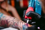 La tinta de los tatuajes puede acumularse en los ganglios linfáticos y aumentar el riesgo de cáncer Un tatuador profesional realiza un tatuaje en el brazo de una joven