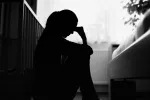 Relacionan cambios en áreas cerebrales con síntomas de depresión posparto Silueta de una mujer sentada apoyada en la cuna y sujetándose la cabeza con una mano