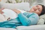 Preeclampsia y hemorragias, entre otros trastornos, causan la muerte de miles de embarazadas Mujer embarazada con gesto de malestar tumbada en un sofá