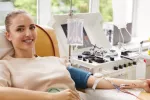 La donación de sangre frecuente produce beneficios genéticos frente al cáncer Mujer joven sonríe mientras dona sangre