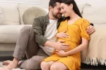 Nueva Guía gratuita con consejos para una concepción y embarazo saludables y seguros Mujer embarazada y su pareja sonríen felices acariciando su tripa