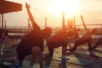 Hacer ejercicio por la tarde puede mejorar la glucosa y prevenir diabetes y obesidad Personas hacen yoga al aire libre al atardecer