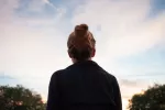 Asocian la menopausia precoz y alteraciones sinápticas a más riesgo de alzhéimer Mujer joven de espaldas contempla el atardecer