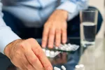 La combinación de dos medicamentos para rebajar el colesterol reduce el riesgo de patologías cardíacas Hombre extrae medicamentos del blíster