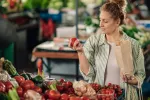 Una dieta rica en ciertos alimentos ayuda a cumplir los 70 con salud Mujer observa una fruta antes de comprarla en el supermercado