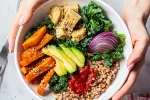 Una dieta rica en alimentos vegetales beneficia a pacientes renales Manos de mujer sostienen plato con hortalizas al horno, aguacate, tofu, etcétera