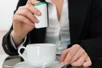 Las señales de hambre en el cerebro se pueden alterar al tomar edulcorantes sin calorías Mujer añade un edulcorante sin calorías a su taza de café con leche
