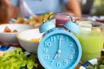 Restringir alimentos 3 días por semana adelgaza más que contar calorías a diario Persona come frente a varios platos de alimentos y un reloj