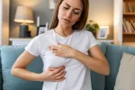 Ácidos grasos omega 6 contribuyen al crecimiento del cáncer de mama triple negativo Mujer joven se palpa pecho izquierdo con cara de preocupación