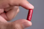 Un fármaco experimental muestra eficacia contra cepas virales resistentes del SARS-CoV-2 Mano de hombre sostiene una cápsula en la que se lee Anti Covid