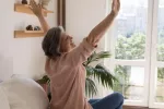 La soltería en la edad adulta puede reducir el riesgo de deterioro cognitivo Mujer mayor se estira feliz frente a la ventana de su habitación por la mañana