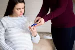 Tener diabetes antes o durante el embarazo aumenta el riesgo de alteraciones del neurodesarrollo en el bebé Una mujer embarazada controla el azúcar en sangre con gesto preocupado