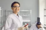 Analizar un biomarcador en sangre identifica a personas en riesgo de alzhéimer Científica en laboratorio sonríe a la cámara sosteniendo un tubo de ensayo con sangre