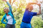 Combinar dieta mediterránea baja en calorías y ejercicio mejora salud ósea en mayores con síndrome metabólico Dos adultos mayores sonrientes hacen ejercicio al aire libre