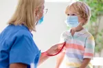 Niños y jóvenes con COVID persistente pueden sufrir problemas renales, gastrointestinales o cardiovasculares Doctora ausculta a un niño con COVID persistente