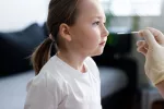 Los niños no vacunados contra el coronavirus tienen más riesgo de COVID persistente Niña pequeña se somete a una prueba de COVID en su casa