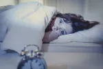 Las zonas del cerebro afectadas por los trastornos del sueño difieren en función de si son a corto o largo plazo Mujer joven con los ojos abiertos en la cama sin poder dormir
