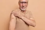 Vacunarse contra el herpes zóster puede proteger frente a patología cardiovascular Hombre mayor sonriente muestra el brazo con una tirita donde le han puesto la vacuna