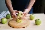 Pelar la fruta ¿es bueno o malo? Hombre pelando la piel de una manzana verde