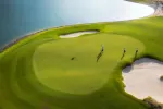 Tres jugadores en campo de golf con una zona con agua
