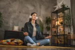 Una terapia cognitiva basada en meditación de atención plena es eficaz contra la depresión Mujer joven sentada en su casa con auriculares siguiendo una sesión de mindflulness guiada