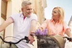Pareja madura se desplazan en bicicleta por la ciudad Hombre y mujer de mediana edad montando en bicicleta